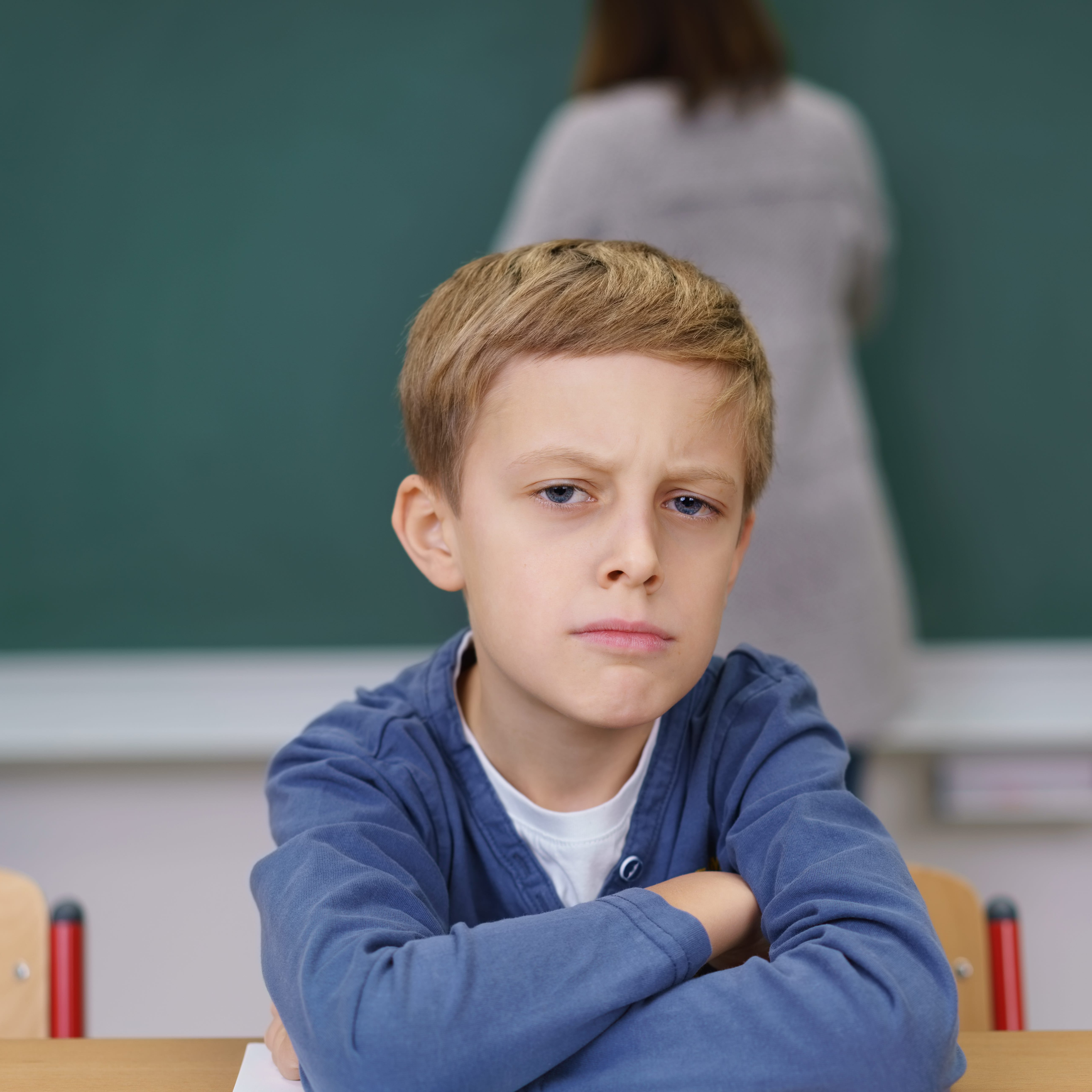 Schüler schaut böse und mit verschränkten Armen